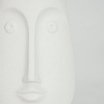 Closeup image of white ceramic abstract face sculpture for modern shelf decor styling with smooth matte finish.