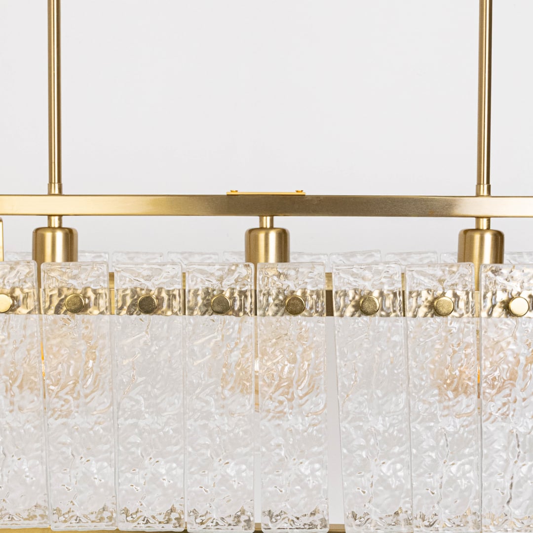 Closeup of gold chandelier with clear crystal glass droplets showing intricate detail and premium craftsmanship luxury lighting.