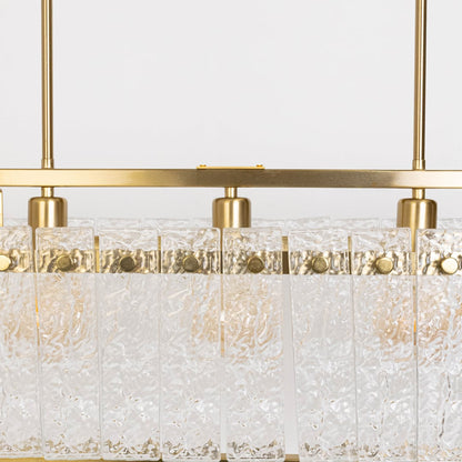 Closeup of gold chandelier with clear crystal glass droplets showing intricate detail and premium craftsmanship luxury lighting.