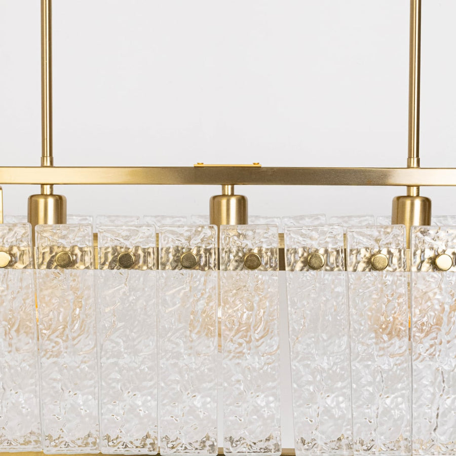 Closeup of gold chandelier with clear crystal glass droplets showing intricate detail and premium craftsmanship luxury lighting.
