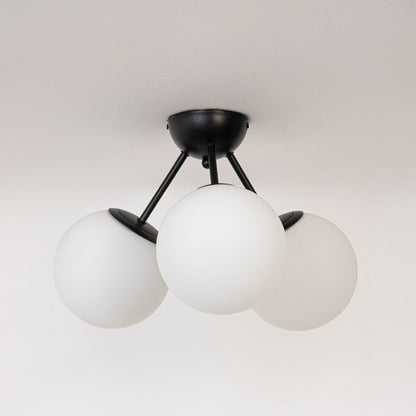 Black ceiling light with three frosted glass globes in off mode displayed on white background for modern ceiling lighting.