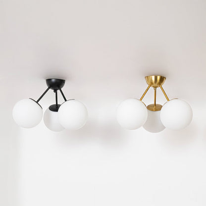 Black and gold ceiling lights with frosted glass globes displayed in off mode on white background for modern home decor.