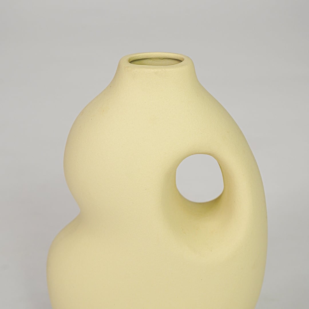 Yellow ceramic decorative vase closeup modern flower vase for shelf console table living room home decor styling.