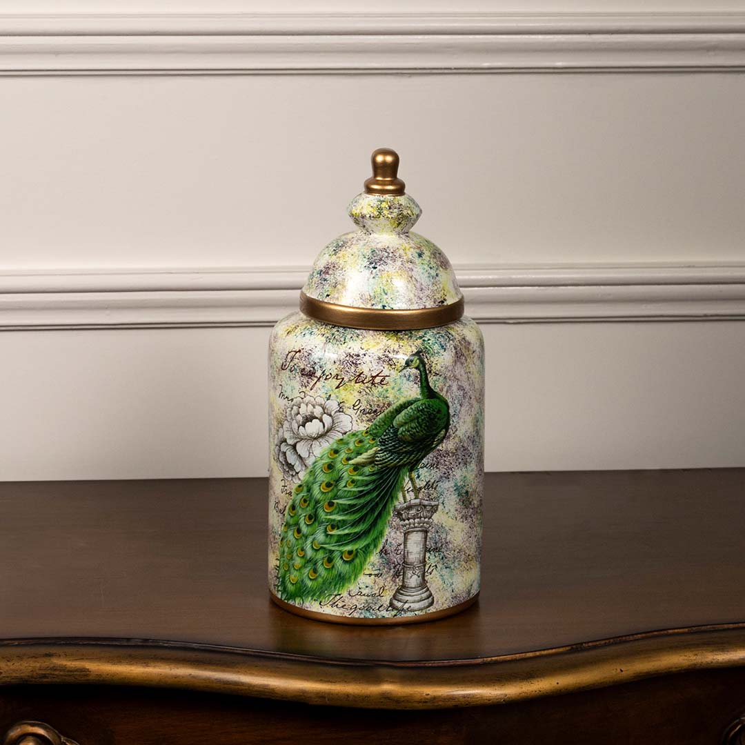 Elegant ceramic jar with a hand-painted peacock motif and golden lid perfect for sophisticated home or tabletop decoration.