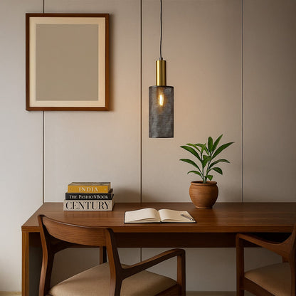 Gold brass pendant light with perforated metal shade creating warm ambient glow in modern industrial interior design space.