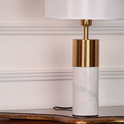 Marble table lamp base closeup highlighting smooth white stone texture brushed brass finish and refined modern craftsmanship.