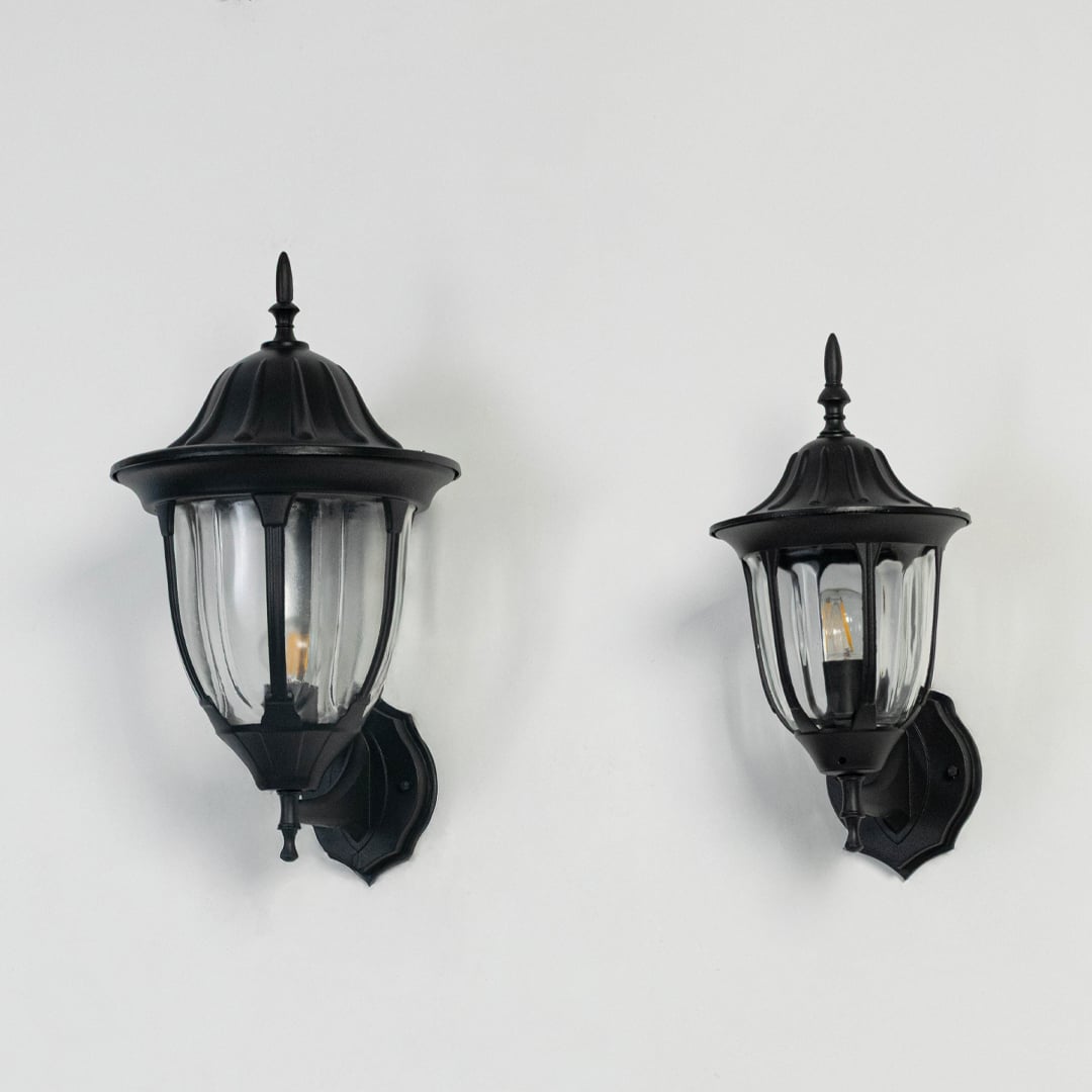 Collection of black outdoor wall mount lanterns switched off on white background displaying classic exterior light fixtures.