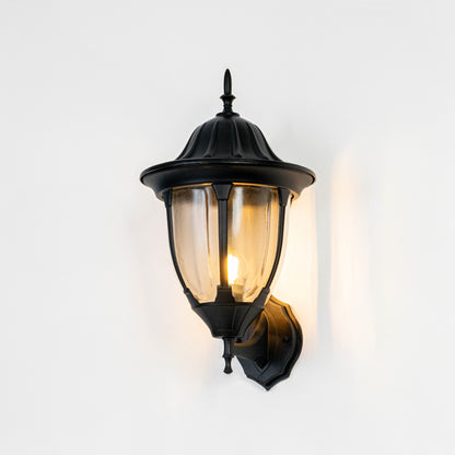 Black metal outdoor wall light on white background with warm glow for stylish patio lighting decor.