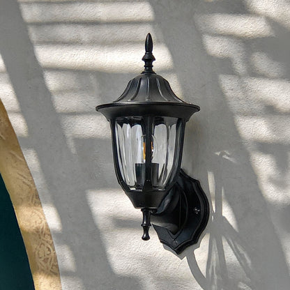 Black metal outdoor wall light lifestyle image with ribbed glass shade for elegant exterior entryway decor.