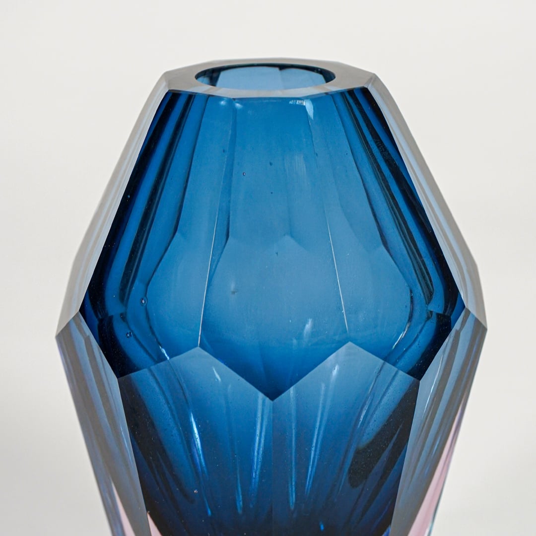 Close up view faceted blue pink glass vase showing cut texture glossy finish luxury decor accent for modern home shelf display.