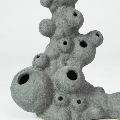 Closeup image of grey ceramic coral decor sculpture for modern shelf styling with artistic textured finish display.