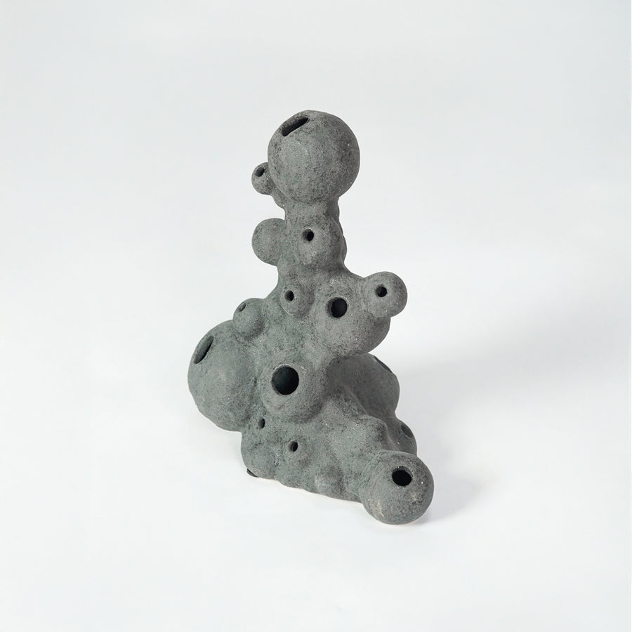 Grey textured ceramic decor object for modern shelf placement and artistic indoor living room styling accent piece.