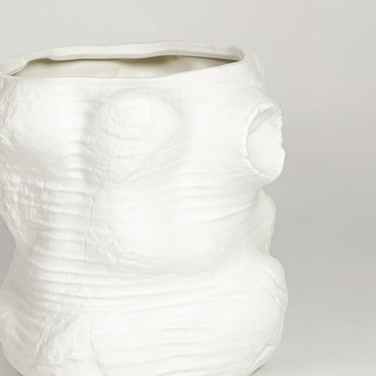 Closeup of matte white ceramic face vase with sculpted abstract features ideal for modern living room shelf or console decor styling.