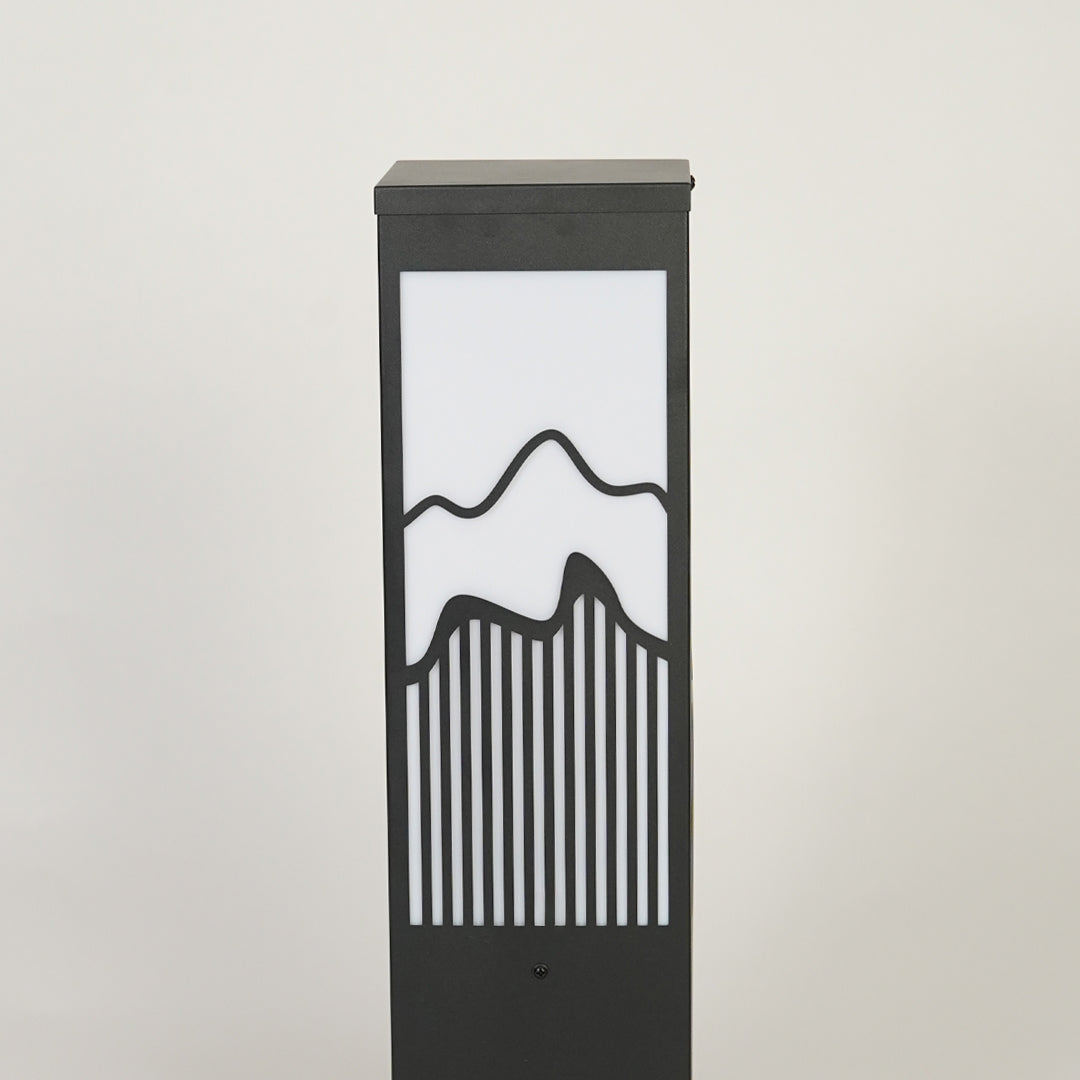 Modern outdoor garden light with rectangular metal frame and patterned glass panel creating soft ambient lighting for pathways.