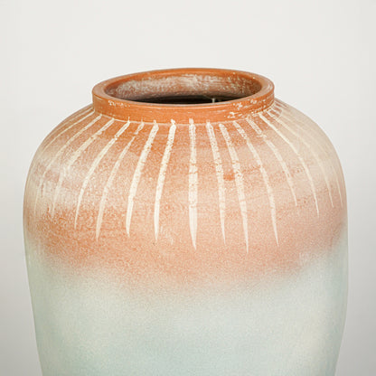 Closeup image of blue and terracotta ceramic decorative vase for modern tabletop styling with textured finish.