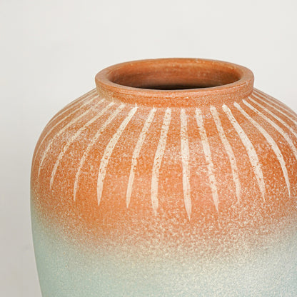 Closeup image of blue and terracotta ceramic decorative vase for modern tabletop styling with textured finish.
