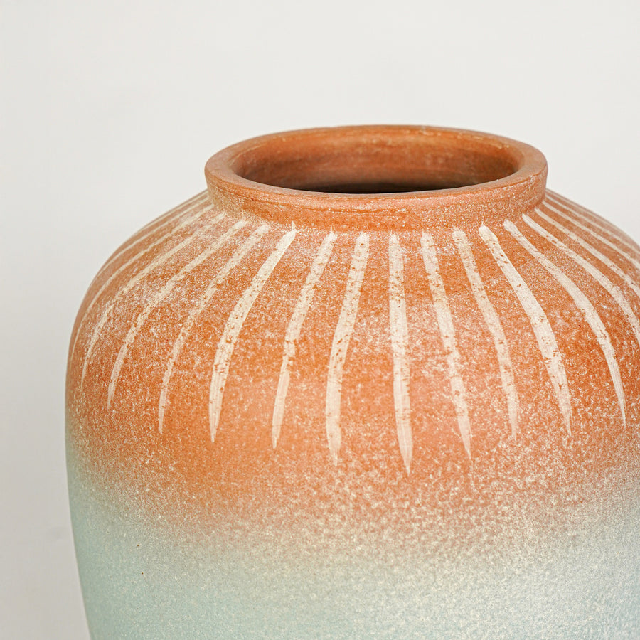 Closeup image of blue and terracotta ceramic decorative vase for modern tabletop styling with textured finish.