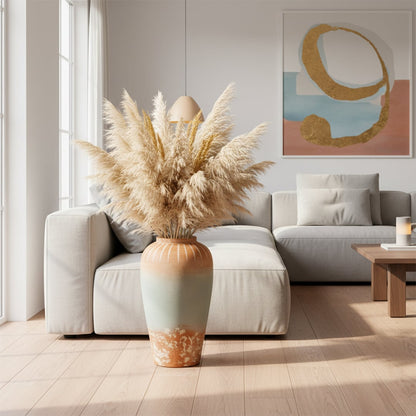White textured floor vase with pampas grass placed beside sofa for elegant rustic home decor.