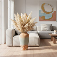 White textured floor vase with pampas grass placed beside sofa for elegant rustic home decor.
