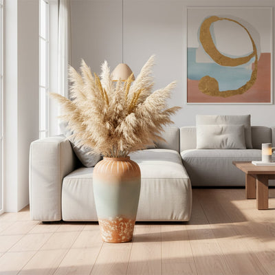 White textured floor vase with pampas grass placed beside sofa for elegant rustic home decor.