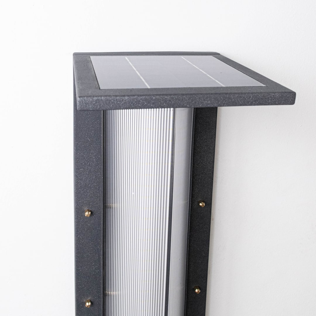 Closeup of modern outdoor bollard light highlighting square solar panel slim metal body and frosted light diffuser detail.