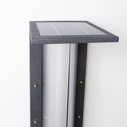 Closeup of modern outdoor bollard light highlighting square solar panel slim metal body and frosted light diffuser detail.