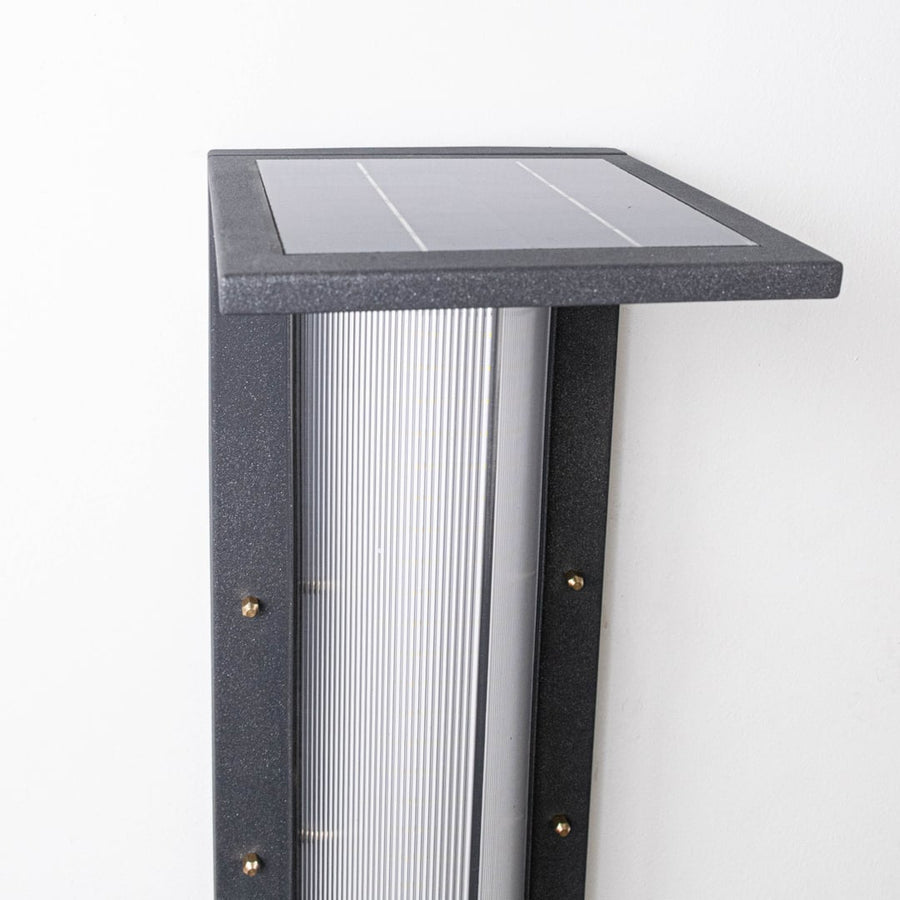 Closeup of modern outdoor bollard light highlighting square solar panel slim metal body and frosted light diffuser detail.