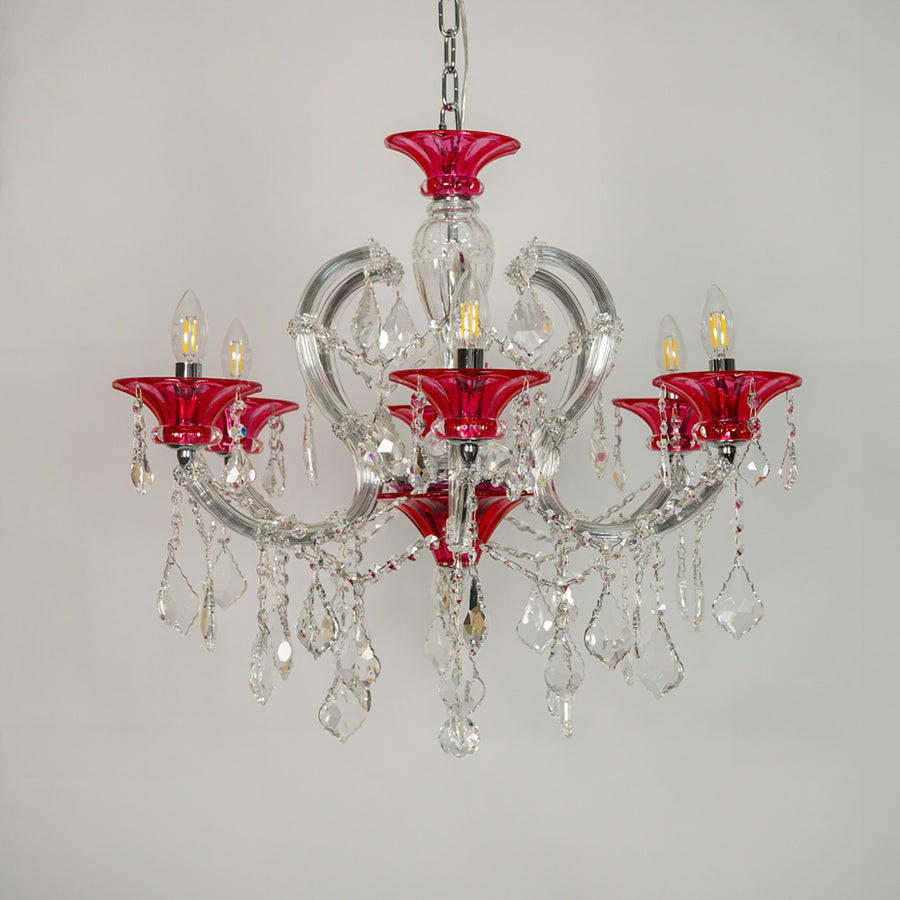 A five-light crystal chandelier featuring vibrant red glass candle-style cups and clear glass teardrop pendants, suspended from a silver chain against a plain light gray background.