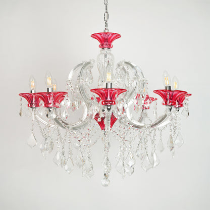 White background image of red and clear glass baccarat style chandelier for elegant dining room decor styling with unlit arms.