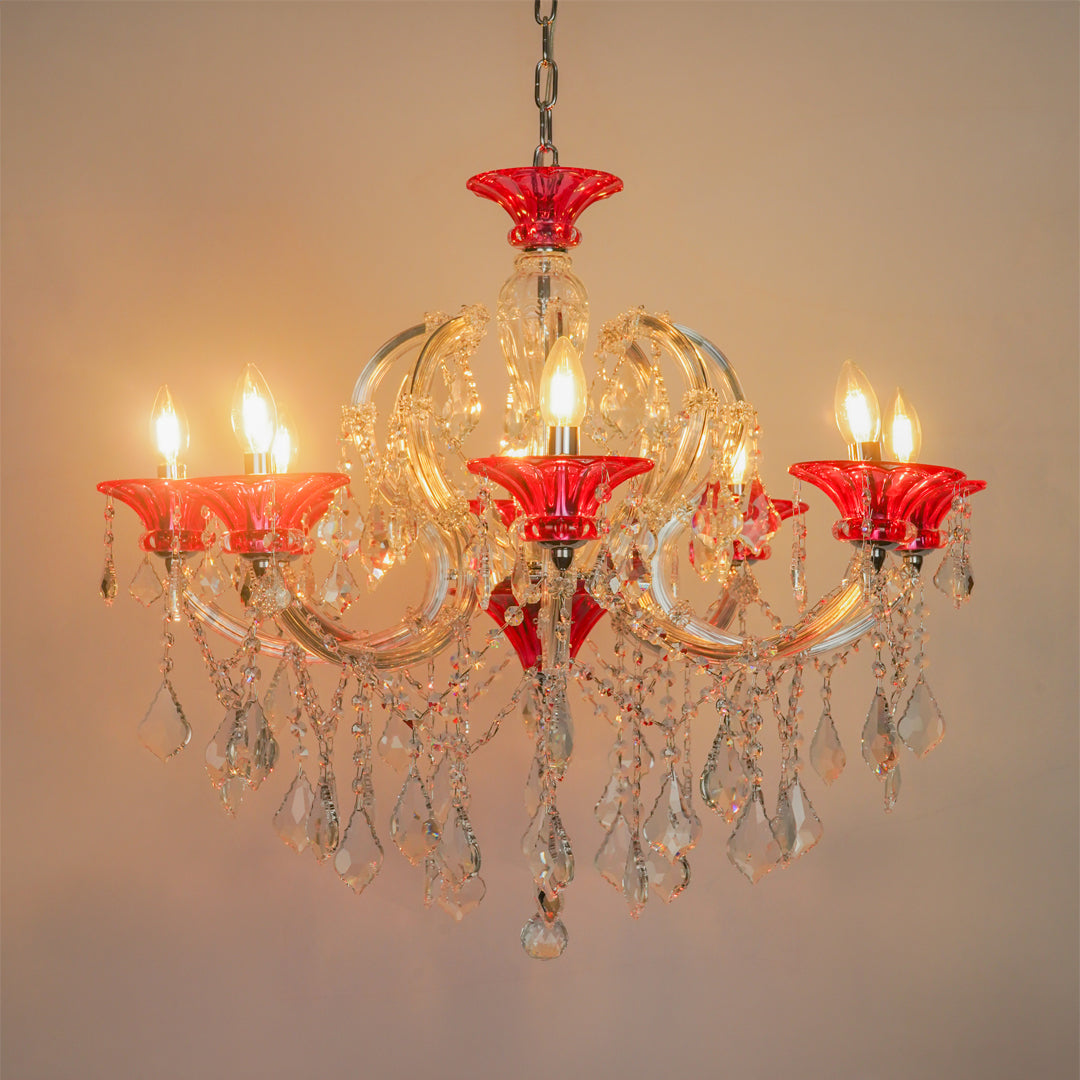 White background image of red and clear glass baccarat style chandelier for modern living room decor styling with a bright warm glow.