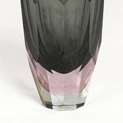 Detailed closeup of grey and pink glass decorative vase highlighting faceted texture and refined glossy surface.