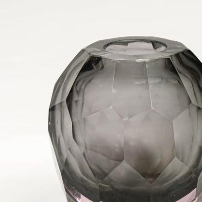 Close view of grey glass decorative bowl highlighting faceted geometric texture and refined glossy finish.