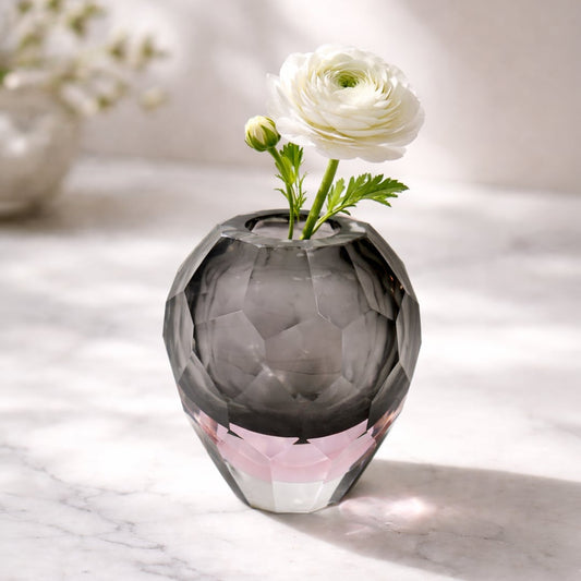 Grey and pink glass decorative bowl styled with floral stem on tabletop enhancing modern and artistic home decor.