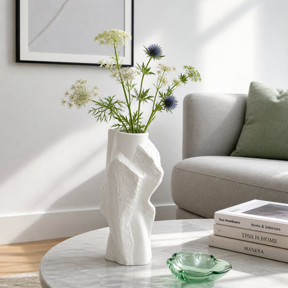 White textured ceramic flower vase with fresh blooms placed on marble table for modern home decor styling.