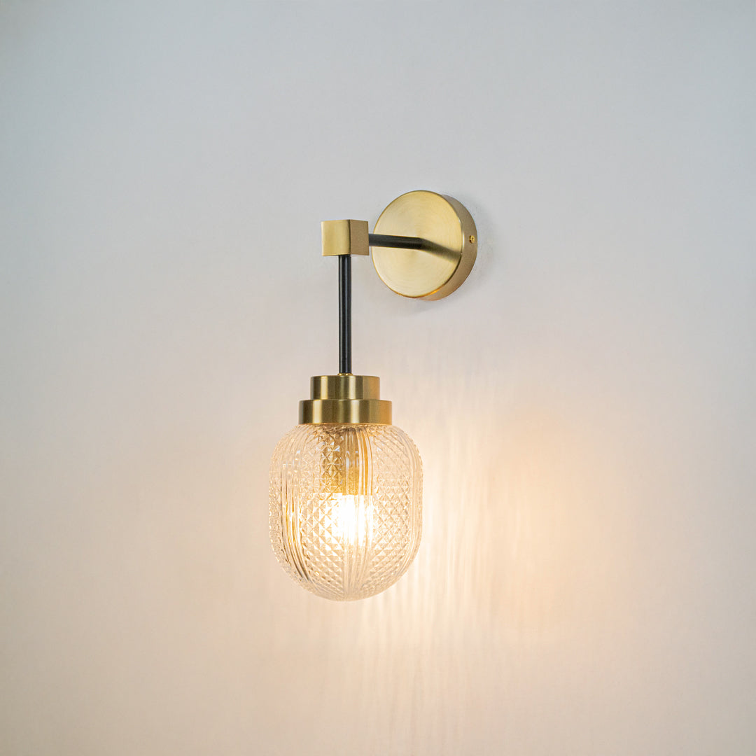 Minimal wall light with gold mount and exposed filament bulb on neutral wall background modern lighting perfect for bedroom living room decor.

