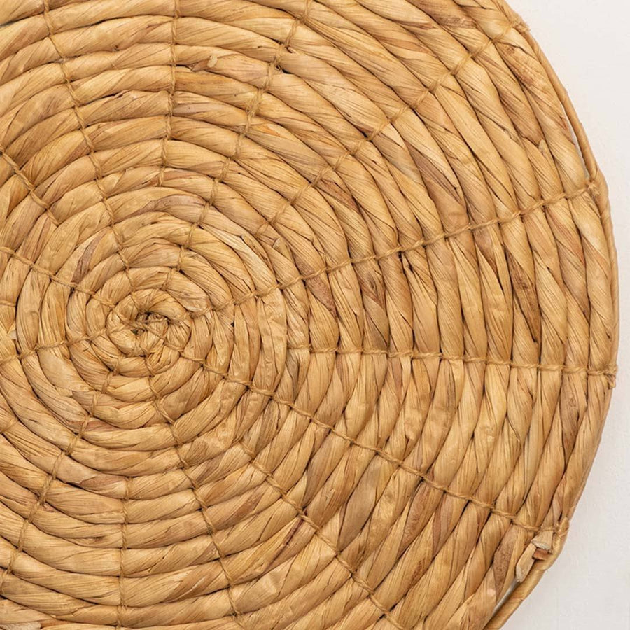 Detailed closeup of handcrafted solid natural wicker seagrass wall basket with woven spiral pattern for artisan decor.