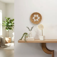 Natural carved wooden wall decor displayed above a floating shelf for warm contemporary home decor and interiors.