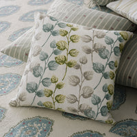 White cotton cushion cover with green botanical print styled on a cozy sofa for fresh living room home decor inspiration.