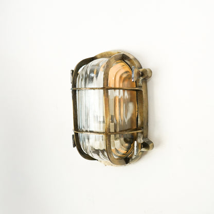 Closeup image of nautical steampunk bulkhead sconce light fixture for elegant home exterior decor and modern wall lighting.