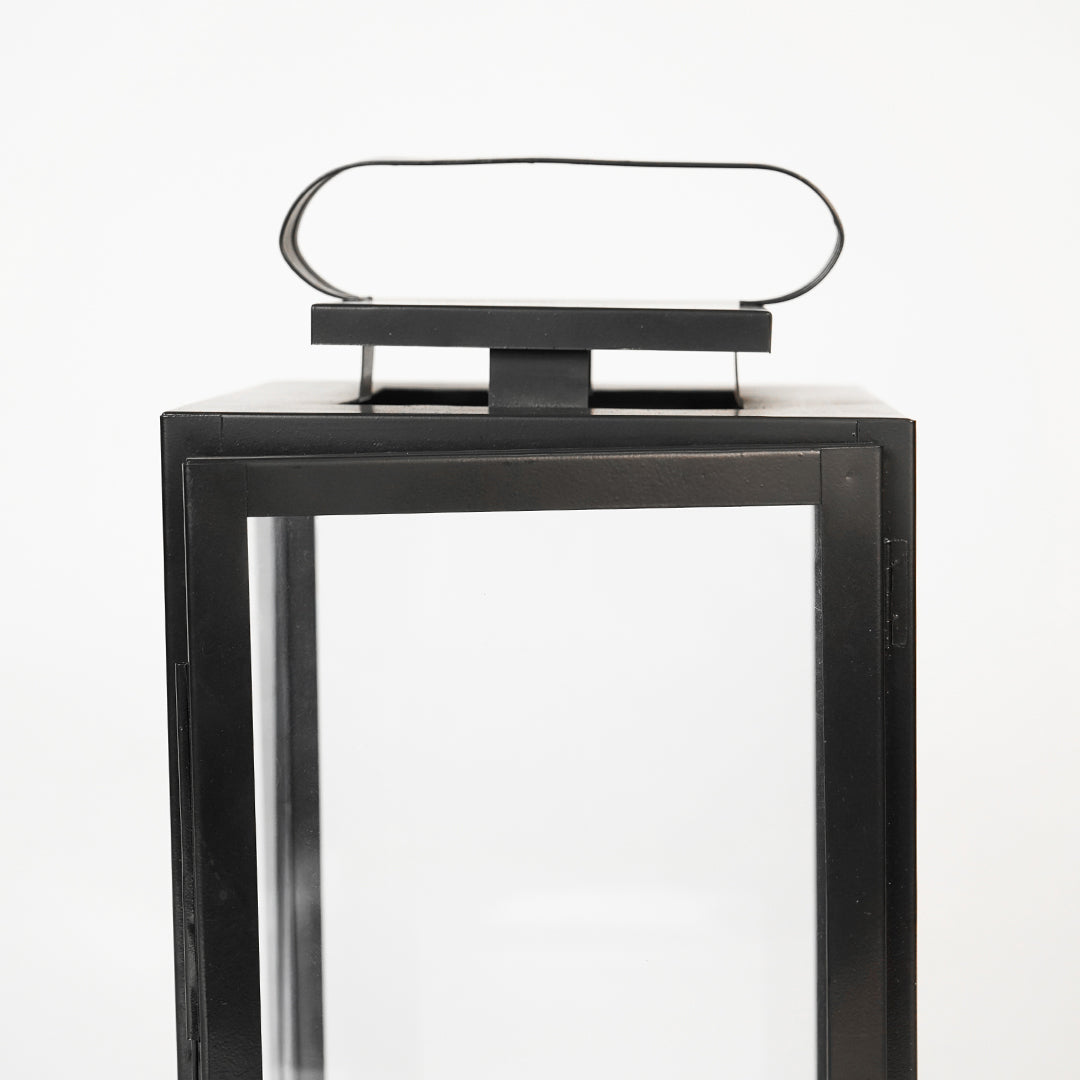Closeup image of large metal tower lantern for modern tabletop decor styling with durable sleek metallic finish detailing.