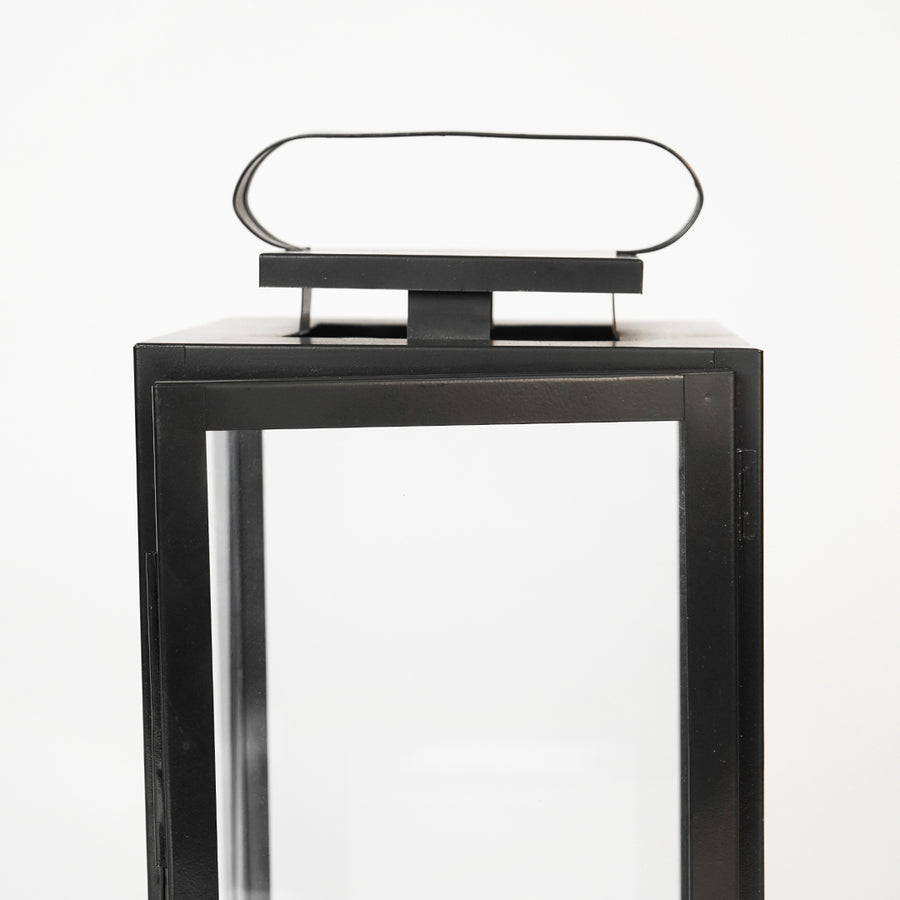 Closeup image of large metal tower lantern for modern tabletop decor styling with durable sleek metallic finish detailing.