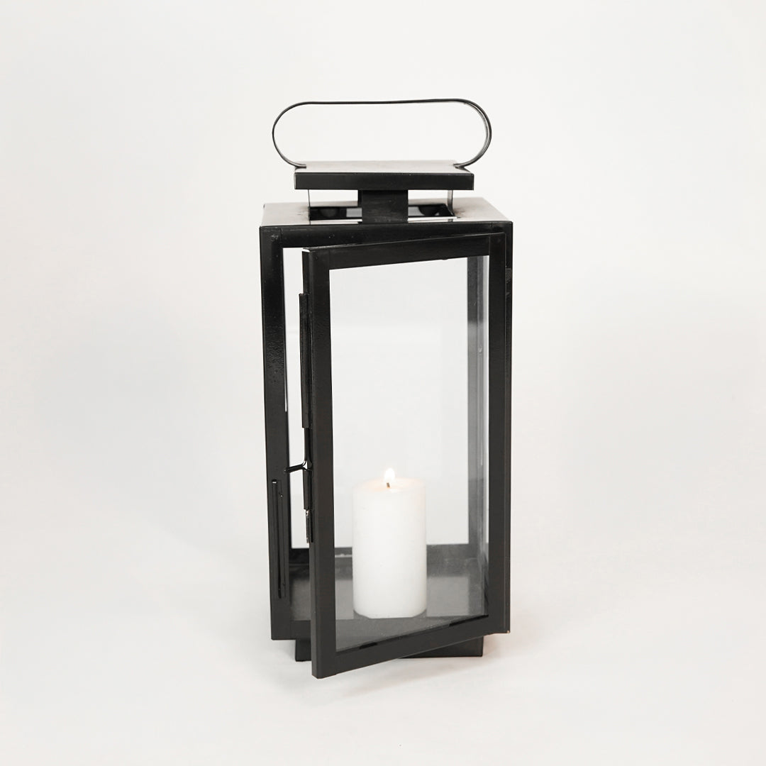 White background image of large metal tower lantern for rustic indoor decor styling showing top handle attachment detail.