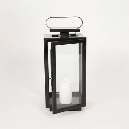 White background image of large metal tower lantern for rustic indoor decor styling showing top handle attachment detail.