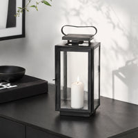 Lifestyle image of medium metal tower lantern for rustic patio decor styling and modern outdoor home patio lighting.