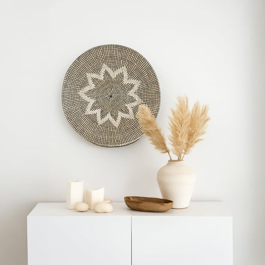 Large handwoven wicker basket wall decor with star pattern styled with vase and candles for modern boho interiors.