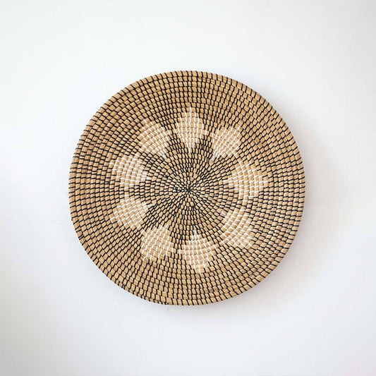 Handwoven seagrass round wall basket decor in natural beige with decorative star pattern centered on white background.