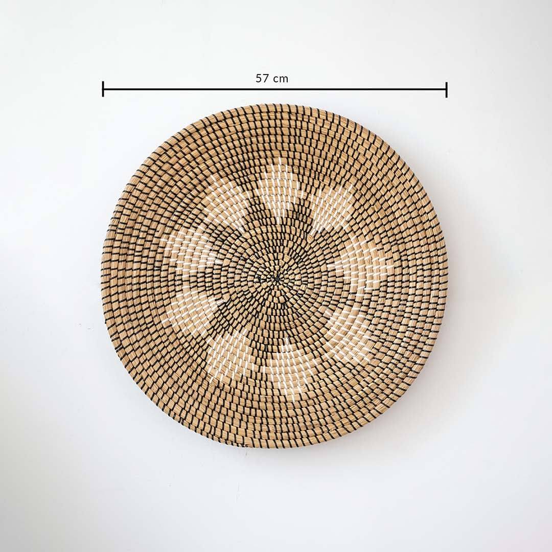 Natural seagrass woven round wall basket decor in beige with geometric star pattern showing product dimensions on white.