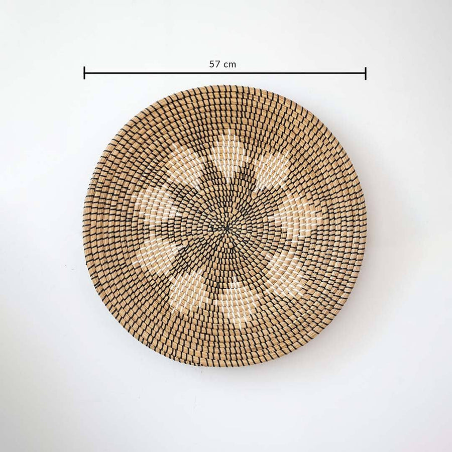 Natural seagrass woven round wall basket decor in beige with geometric star pattern showing product dimensions on white.