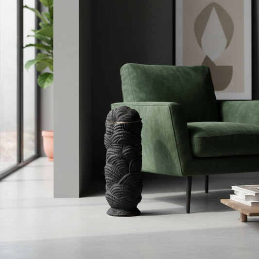 Decorative floor vase crafted in black textured material placed beside green armchair adding modern accent and depth to living room decor.
