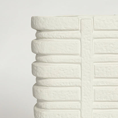 Close up view white ceramic vase showing layered ribbed texture sculpted vertical pattern modern decor accent.